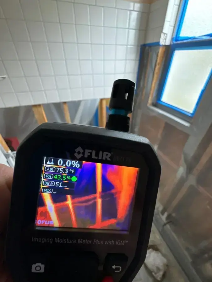 Thermal imaging camera scanning a wall for hidden moisture during a Hempstead water damage walkthrough